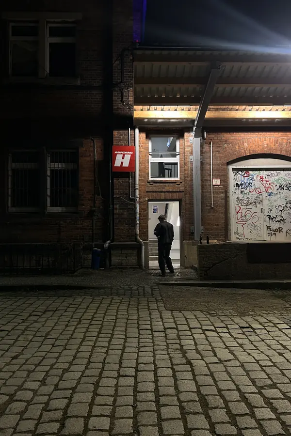 Beleuchteter Eingang eines Backsteingebäudes bei Nacht
